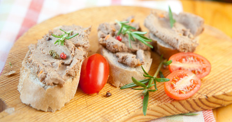 Chicken liver pate on bread with cherry tomatoes and a sprig of rosemary 