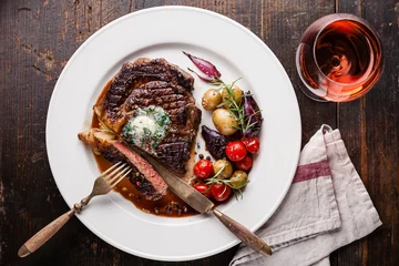 Tuinposter Steakhouse Gesneden medium rare gegrilde Biefstuk Ribeye met kruidenboter en