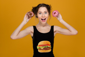 Lovely woman in black top with hamburger print holding donuts