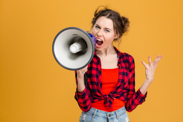 Angry mad young woman screaming in megaphone