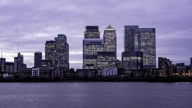Timelapse view of office buildings in the financial district of the Docklands in London as seen from North Greenwich after sunset. Transition into night