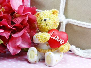 teddy bear sitting with a red heart and christmas gift boxes wrapped