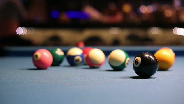 Playing Eight-ball pool billiards in a bar