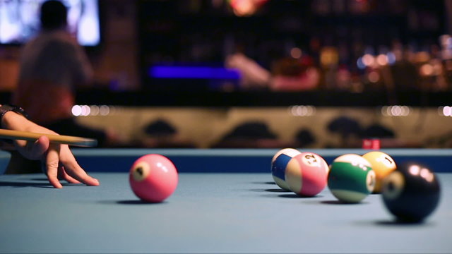 Playing Eight-ball pool billiards in a bar