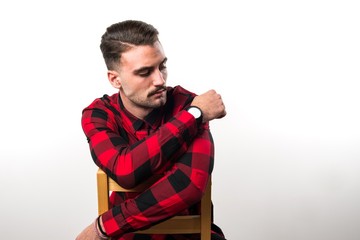 Fototapeta premium Model man in studio sitting on wooden chair
