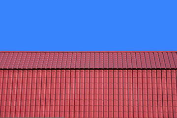 Front view of new gable red house roof covered with metal tile isolated on blue background closeup