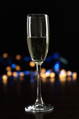 A glass of champagne with bokeh on dark background