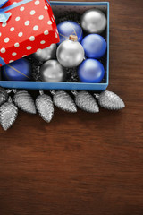 Box with Christmas toys on wooden background