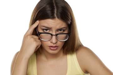 young beautiful woman with glasses and a questioning gesture 