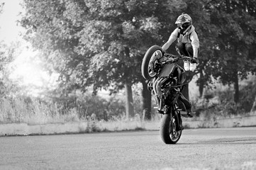 His only passion. Black and white soft smudged focus portrait of a stuntman doing tricks on a bike copyspace on the side