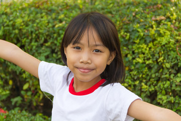 Asian cute child in white shirt playing in the garden