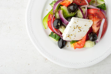 Greek salad on the white scratched table top view
