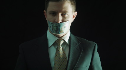 The politics in a suit closes mouth with the hundred-dollar banknote