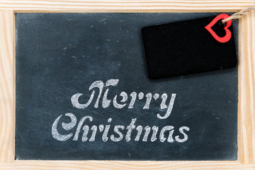 Fototapeta na wymiar Wooden frame vintage chalkboard with Merry Christmas message, tag and red heart shape