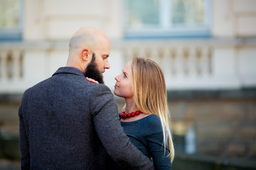 Fototapeta premium Portrait closeup couple of long-haired young sensual woman back arched touching beard of man with moustache bent over girl face holding hair grey background, vertical picture
