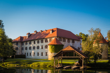 Otocec, Slovenia - September 12, 2015. Grad Otocec, castle in the middle of the river Krka with its dock for boats.