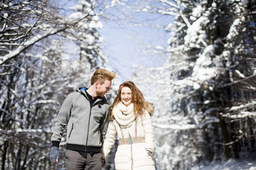 Fototapeta na wymiar Young couple at winter forest