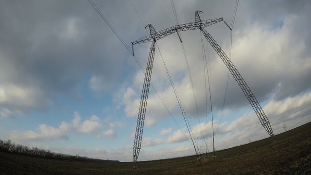 Electric high voltage pylon against sky. Time lapse.