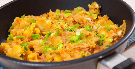 stewed meat with potatoes, onion in a frying pan