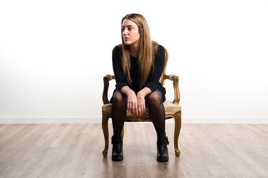Model woman sitting on vintage armchair