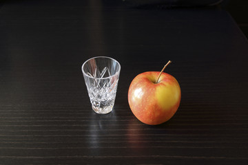 Still life with glass and an apple.