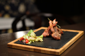 lamb steak with salad on a dark background