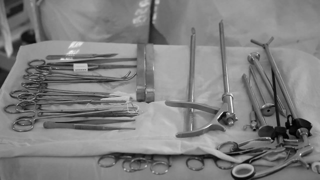 Steel surgical instruments on a sterile white cloth
