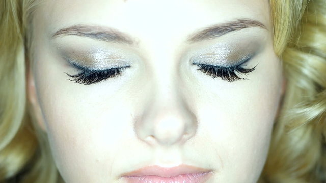 blonde woman with green eyes and long eye lashes closeup 