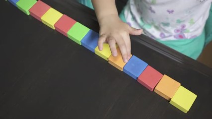 A small child is being taught by a parent or teacher