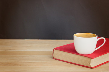 Coffee cup and book over wood