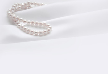 Elegant white background with silk and pearl