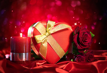 Valentine gift box and rose flower on red silk background