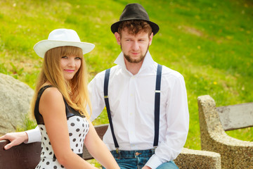 couple retro style sitting on bench in park