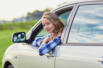 Young confident woman driving a car