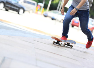 young skateboarder legs riding on skateboard on city © lzf