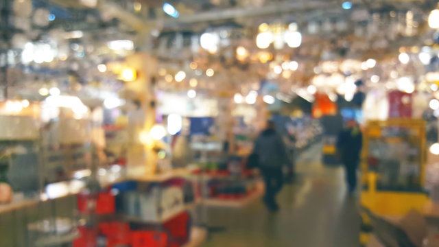 Blurred lights background people in the store fixtures and chandeliers, defocused