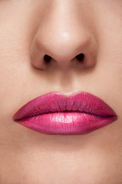 Lips with pink lipstick in close up photo