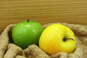 Yellow and green apple on fabric.