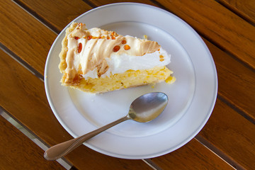 Freshly baked coconut cream pie on wooden table top