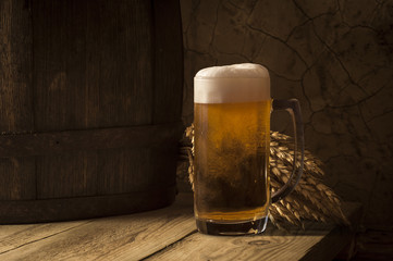 Beer barrel with beer glass on table on wooden background