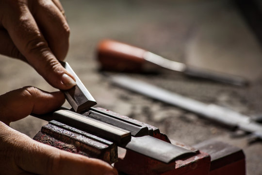 Luthier making a classical guitar bridge plate