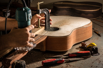 Luthier cutting a channel to place the truss rod in the guitar n - obrazy, fototapety, plakaty