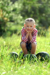 Fototapeta premium Small girl with watermelons on lawn