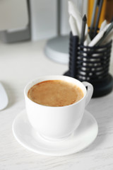 Cup of coffee on workplace background