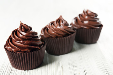 Chocolate cupcakes on light wooden background