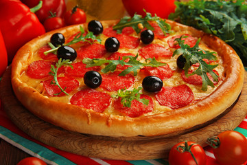 Tasty pizza with salami on decorated wooden table, close up