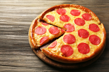 Hot tasty pizza with salami on wooden background