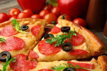 Hot tasty pizza with salami and olives on wooden background, close up