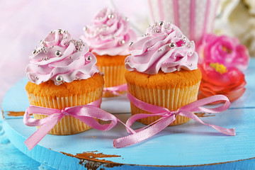Tasty cupcakes on tray, on light background