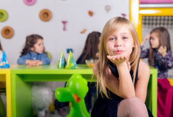 Smiling little girl with her friends at birthday party